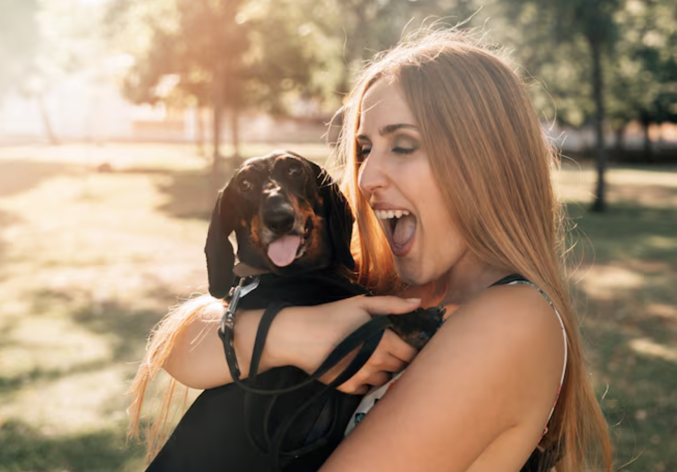 Woman hugging a small black dog